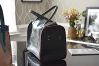 a black handbag sits on a table in a room